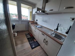 a kitchen with white cabinets and a sink and a window at Altstadthotel garni Frankfurter Hof in Eschwege