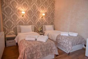 a room with three beds with white towels on them at MariaLuis Hotel in Tbilisi City