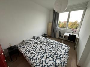 a bedroom with a bed and a window and a table at Castle View Apartment in Budapest