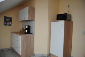 a kitchen with a microwave on top of a refrigerator at Ferienwohnung Arnold in Vöhl