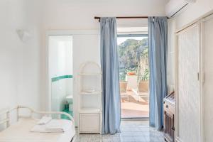 a bedroom with a bed and a door to a patio at Terrazza Tragara in Capri