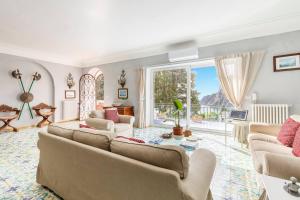 een woonkamer met meubilair en een groot raam bij Terrazza Tragara in Capri
