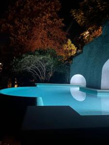 a swimming pool at night with trees in the background at Terrazza Tragara in Capri