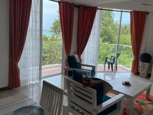 un soggiorno con tavolo, sedie e una grande finestra di Beach Bliss a Trincomalee