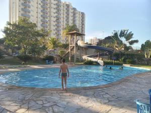 卡达斯诺瓦斯Golden Express Flat B-119 - Conforto e lazer para toda Família的站在游泳池里的男孩