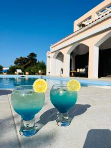 dos vasos de bebida azul con rodajas de limón en ellos en Villa LP Kokkino Chorio en Vamos