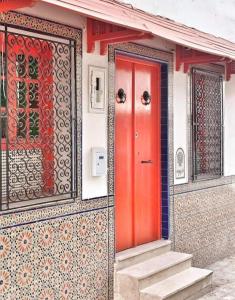蘇塞的住宿－Dar Youssef Medina Sousse，一个小房子的红色门,有楼梯