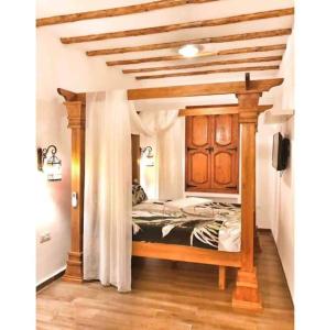 a bedroom with a bed with a wooden canopy at Dar Youssef Medina Sousse in Sousse