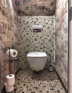 a bathroom with a toilet and a tiled wall at Dar Youssef Medina Sousse in Sousse