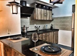 a kitchen with a black counter top with two wine glasses at Dar Youssef Medina Sousse in Sousse
