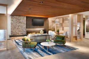 een woonkamer met een open haard en een televisie bij Fairfield by Marriott Inn & Suites Salt Lake City Cottonwood in Holladay