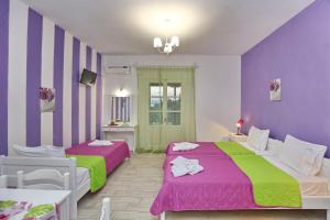ネオ・キリマにあるEvaggelia Studiosの紫と緑の部屋のベッド2台