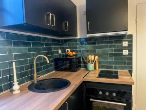 a kitchen with a sink and a counter top at Confort & modernité au centre de Tarbes in Tarbes