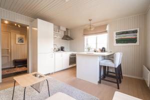 a kitchen with white cabinets and a counter and a table at White House - Panoramic View in Reine