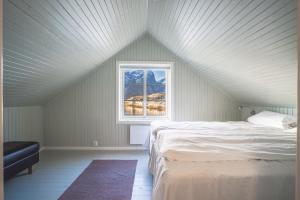 a bedroom with a bed and a window at Little White House in Reine