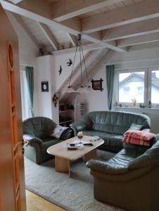 a living room with two green couches and a table at Maison Christa in Bad Kissingen