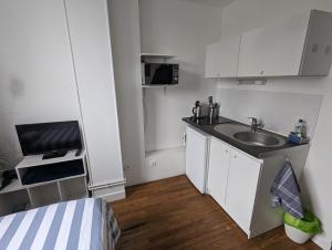 a small kitchen with a sink and a microwave at Cosy Studio Amiens in Amiens