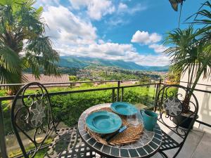 einen Tisch mit blauen Platten auf dem Balkon in der Unterkunft Suite Apartment with a view and free parking in Lugano