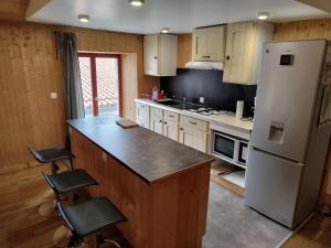 帕爾特奈的住宿－Le Chalet，厨房配有冰箱和带凳子的台面