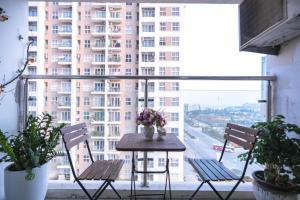 una mesa y sillas en un balcón con un gran edificio en Căn hộ 3 ngủ gần biển, en Ha Long