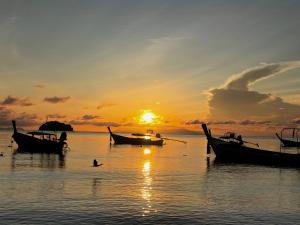 a group of boats in the water at sunset at Sea To Moon Lipe in Ko Lipe