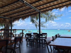 麗貝島的住宿－Sea To Moon Lipe，海滩上的餐厅,配有桌椅
