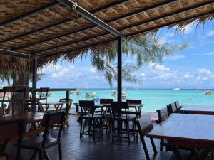 ein Restaurant am Strand mit Tischen und Stühlen in der Unterkunft Sea To Moon Lipe in Ko Lipe