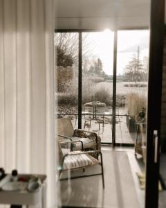 a screened in porch with a couch and a table at Lit de Clémot in Merelbeke