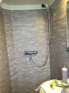 a shower in a bathroom with a tile wall at Mitt i vackraste Bohuslän in Lysekil