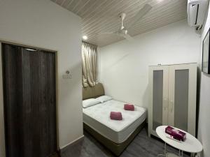 a small room with a bed and a table at Santai De Lui Resorts in Kampong Mesjid