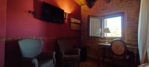 Hotel Rural Abuelo Rullo في Terriente: غرفة معيشة مع كرسي ونافذة
