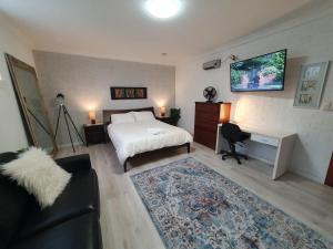 1 dormitorio con cama, escritorio y sofá en Grandview Melbourne Executive 2BR Apartment en Melbourne