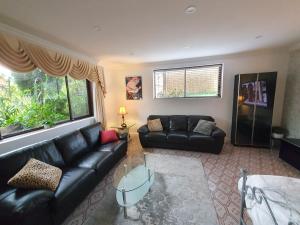 una sala de estar con sofás de cuero negro y una ventana en Grandview Melbourne Executive 2BR Apartment en Melbourne