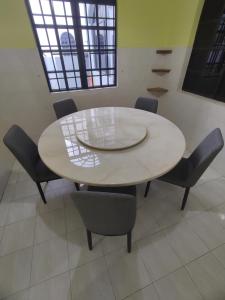 una mesa blanca y sillas en una habitación en Ipoh Tambun Sunway 5 Rooms Spacious Homestay en Tambun