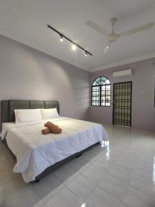 een slaapkamer met een groot bed met witte lakens en een plafond bij Ipoh Tambun Sunway 5 Rooms Spacious Homestay in Tambun