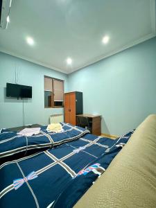 Schlafzimmer mit einem großen Bett mit blauer Decke in der Unterkunft Armenia Guest House in Komitas in Yerevan