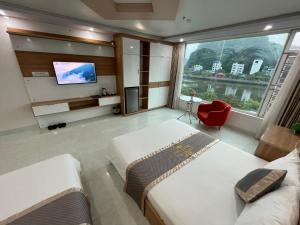 a hotel room with two beds and a flat screen tv at Seoul Motel Seaview in Cat Ba