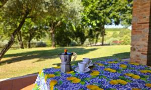 einen Tisch mit einer Teekanne und Tassen darauf in der Unterkunft Pian della Bandina in Città della Pieve