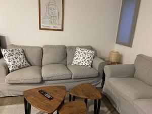 ein Wohnzimmer mit einer Couch und zwei Tischen in der Unterkunft El patio de Rio Lozoya in Buitrago del Lozoya