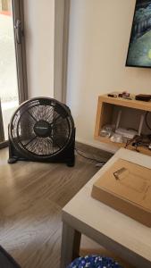 a black fan sitting on the floor in a room at Camelia Bldg, Groundfloor, 3 min to beach in Flic-en-Flac