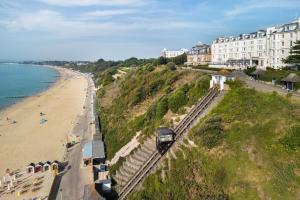 a train traveling down tracks next to a beach at Bournemouth Highcliff Marriott Hotel in Bournemouth