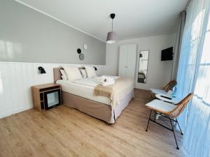 sypialnia z dużym białym łóżkiem i krzesłem w obiekcie Strandhuus Norddeich w mieście Norddeich