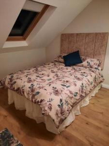 a bedroom with a bed with a blue pillow on it at Radharc an Chuain 2 Bedroom Holiday Home in Galway