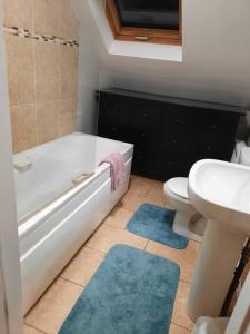 a bathroom with a tub and a toilet and a sink at Radharc an Chuain 2 Bedroom Holiday Home in Galway