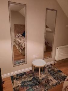 a room with two mirrors and a table and a bed at Radharc an Chuain 2 Bedroom Holiday Home in Galway