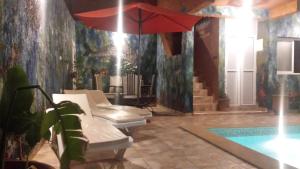 una stanza con piscina e ombrellone rosso di Mirleft Tayought Guest House a Mirleft