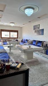 uma sala de estar com mobiliário azul e um lustre em appartement tout confort em Meknès
