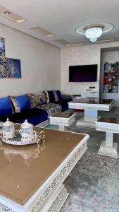 uma sala de estar com um sofá e uma mesa em appartement tout confort em Meknès