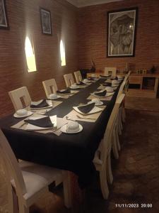a long table with white plates and napkins on it at Riad en exclusivité Maison d hôtes Chamade & Spa in Marrakech