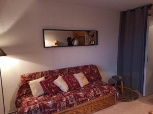 a living room with a couch and a mirror at Chamrousse - Résidence Le Vernon in Chamrousse